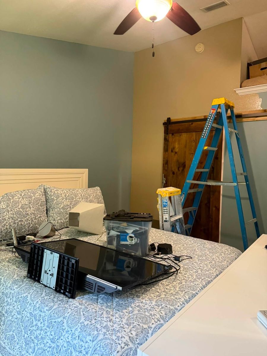 Bedroom repaint in progress with a ladder, paint cans and furniture covered